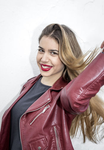 Smiling young woman wearing maroon jacket