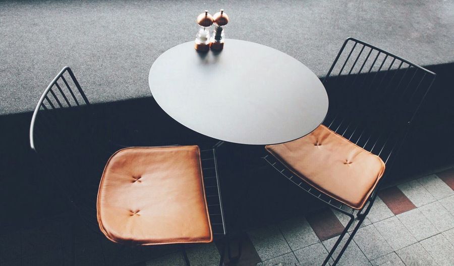 High angle view of empty chairs and table at side cafe
