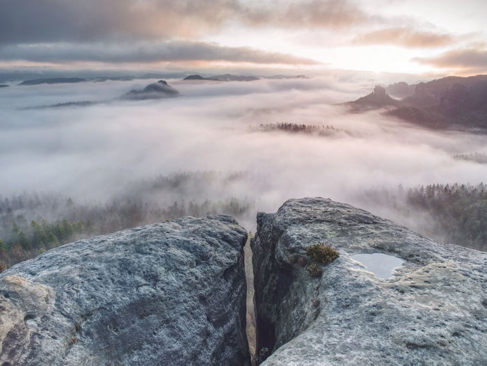 Rocks in nature park in saxony. misty vewpoint with hill and peak in distance. spectacular landscape