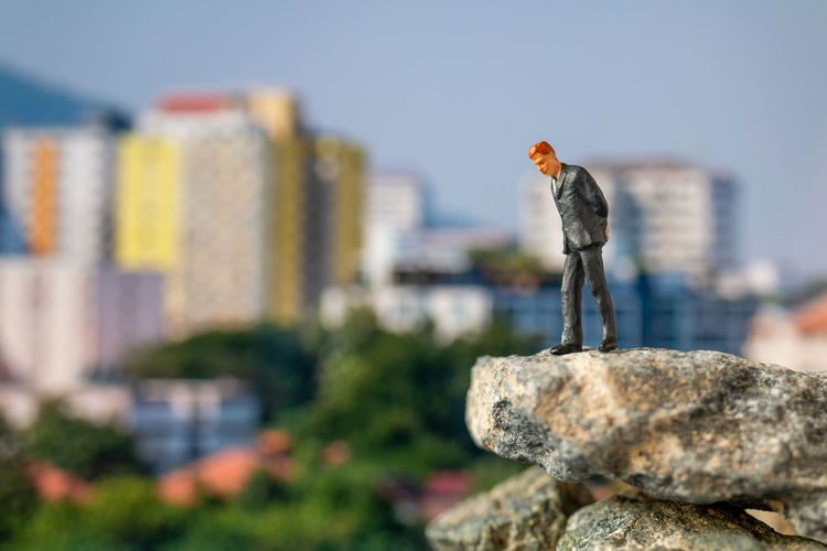 Businessman standing on the rock with building background