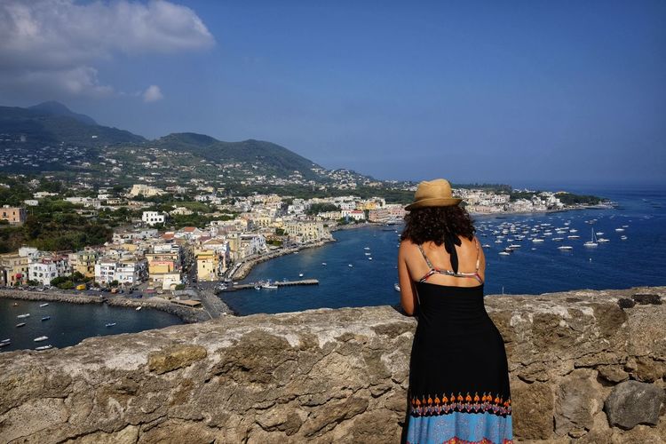 Tourist woman admires ischia panorama
