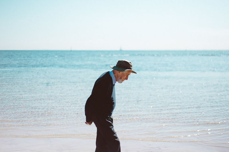 Full length of man standing on beach against sky
