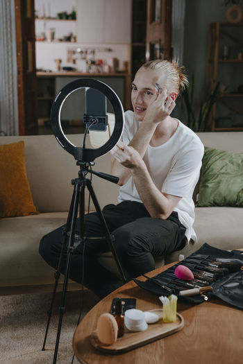 Influencer vlogging make-up tutorial through smart phone at home