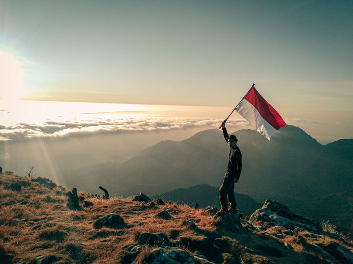 Man standing on mountain against sky