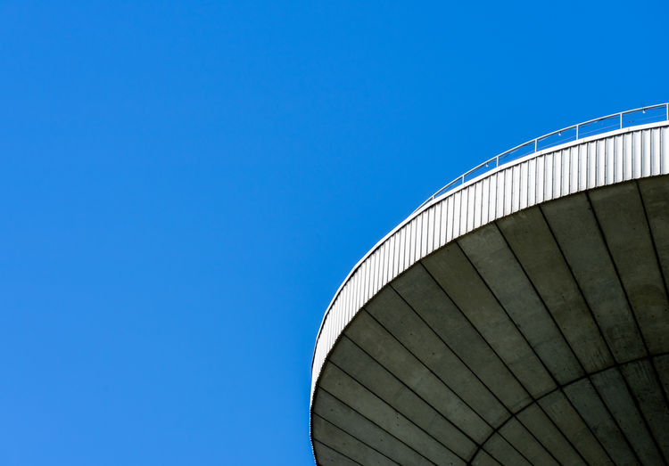 Low angle view of factory against clear blue sky