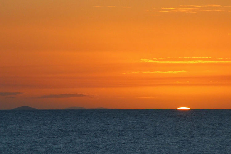 Scenic view of sea against orange sky
