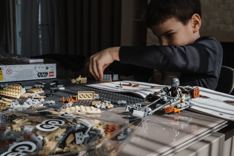21.03.2022. batumi, georgia. boy child manually folds lego constructor at the table. star wars. 