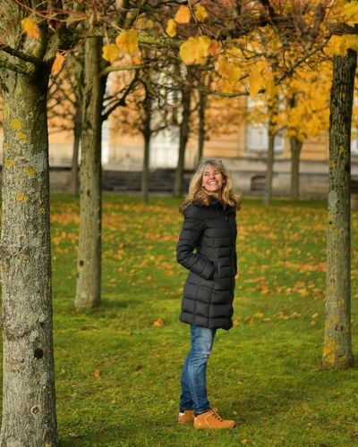 Side view of woman standing in park during autumn