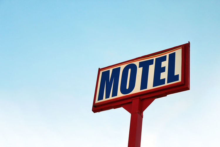 Huge vintage motel sign against blue sky