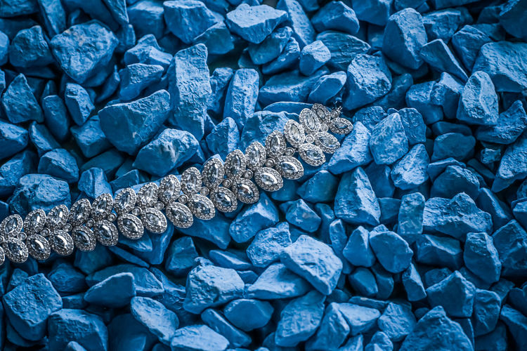 High angle view of diamond necklace on stones