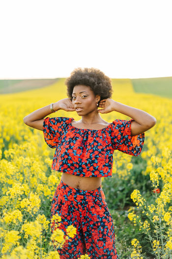Young woman standing on flowering field