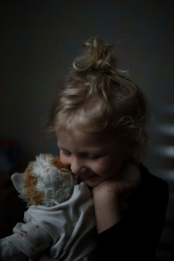 cute girl with stuffed toy at home