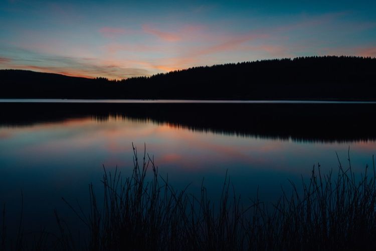 Scenic view of lake against sky at sunset