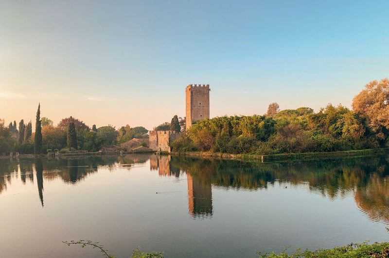 Scenic view of lake by buildings against sky