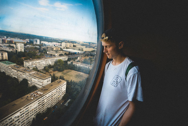 Mid adult man standing by cityscape against sky