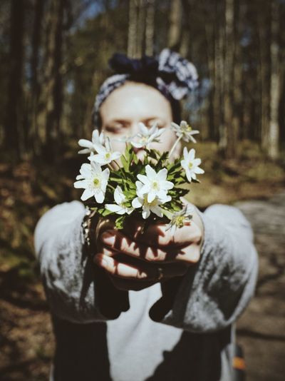 Man holding white flowering plant
