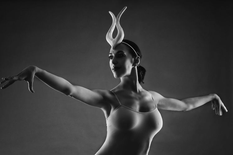 Ballerina dancing against black background