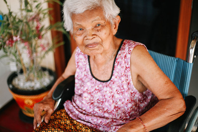 Portrait of smiling woman sitting on chair at home