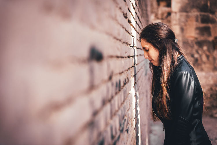 Woman standing by wall