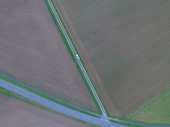 Aerial view of car on road amidst agricultural field