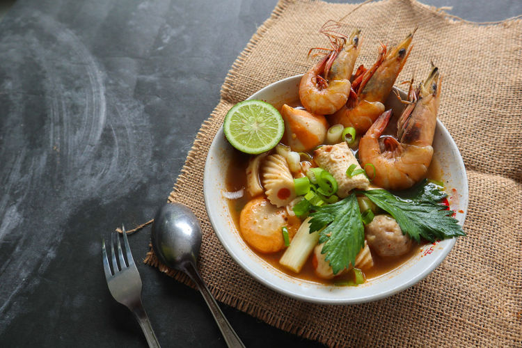 Tom yam soup originating from thailand. tom yum is made with shrimp, chili, lime, chicken, fish, 