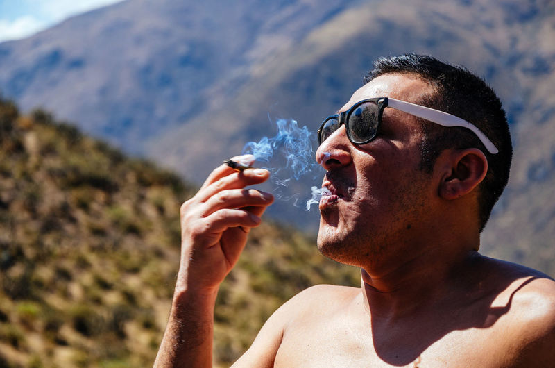Portrait of man drinking water from sunglasses