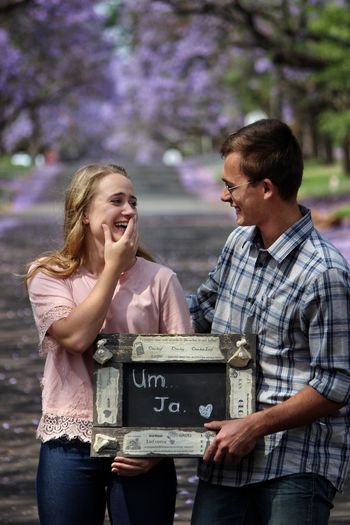 Happy couple holding blackboard with text