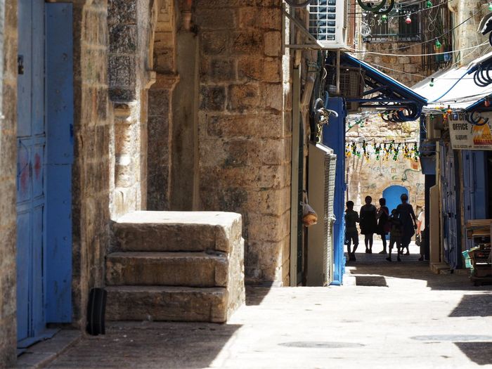 Rear view of people walking on street in city