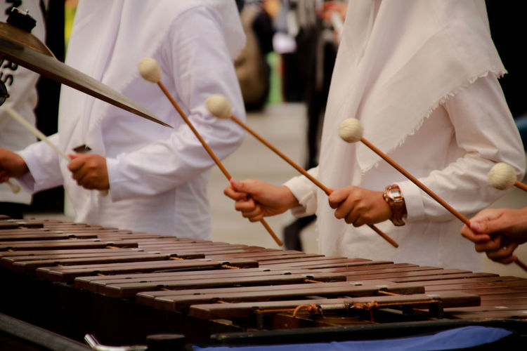 Midsection of men playing musical instrument during celebration