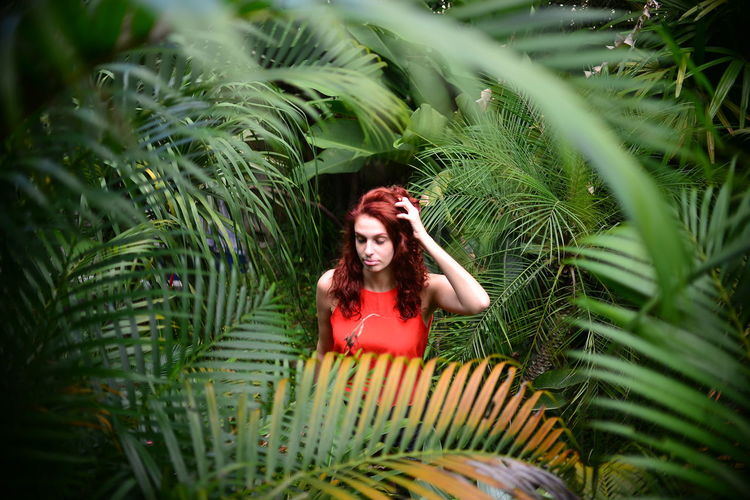 Portrait of young woman surrounded by plants