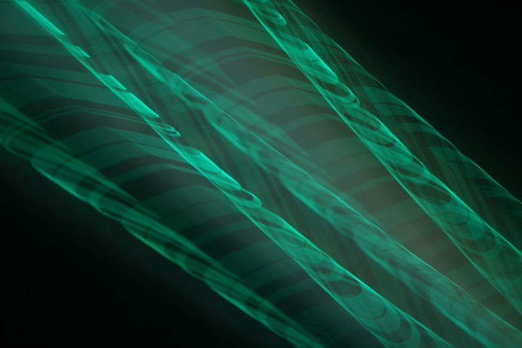 Low angle view of illuminated lights against black background
