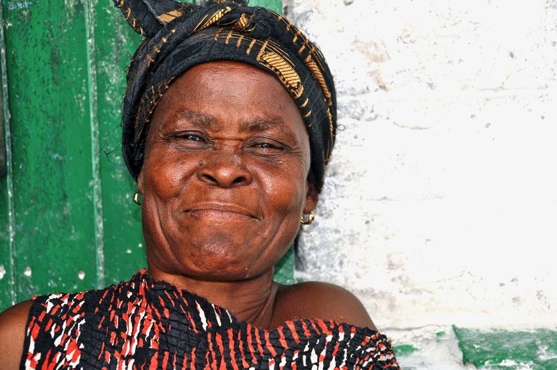 Close-up portrait of smiling woman against wall