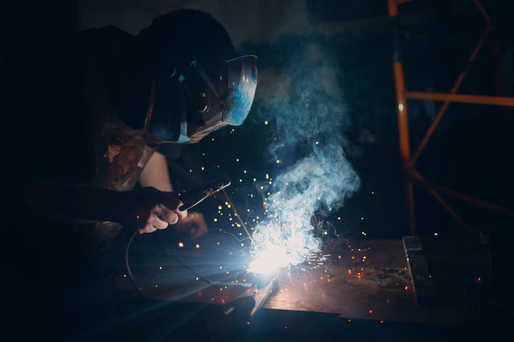 Man welding metal in workshop