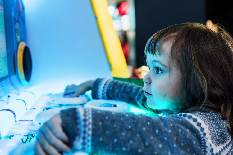 Close-up of girl playing with illuminated game