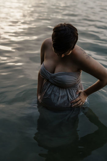 Pregnant woman standing in lake