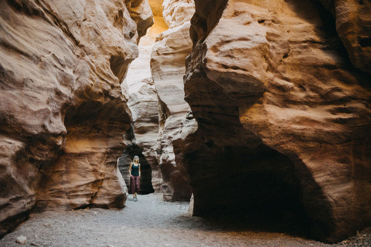 Full length of woman walking in rock formation in cave