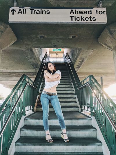 Full length of woman standing on steps at railroad station