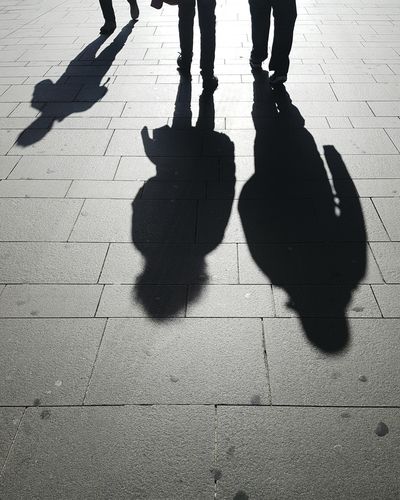Shadow of people walking on footpath