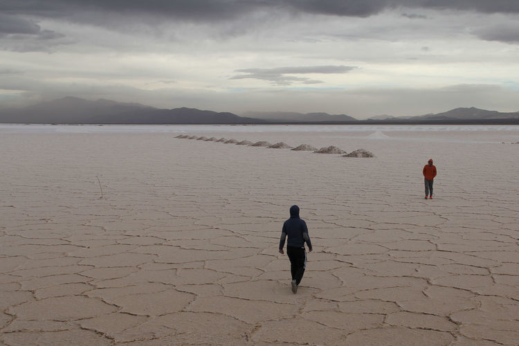 People at salinas grandes against sky