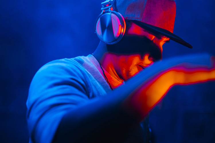 Close-up of man listening music at night