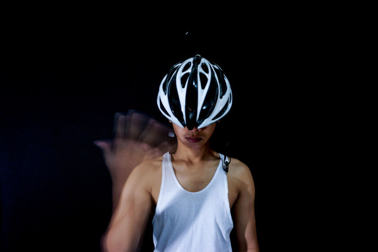 Man wearing sports helmet against black background