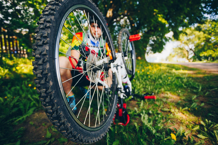 Man repairing bicycle on grass
