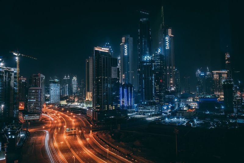 Illuminated buildings in city against sky at night