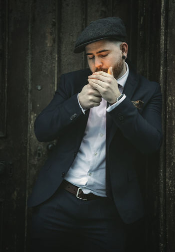 Young man smoking while standing outdoors