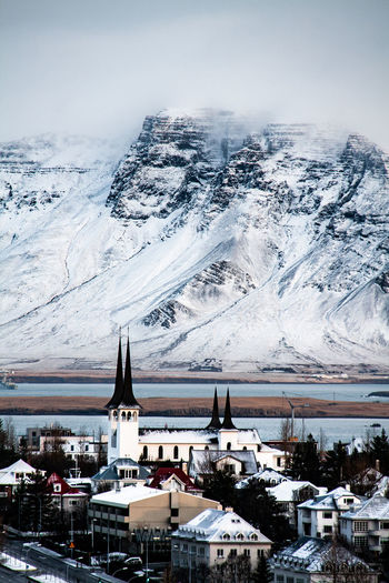 High angle view of townscape against snowy mountains and sky during winter in iceland