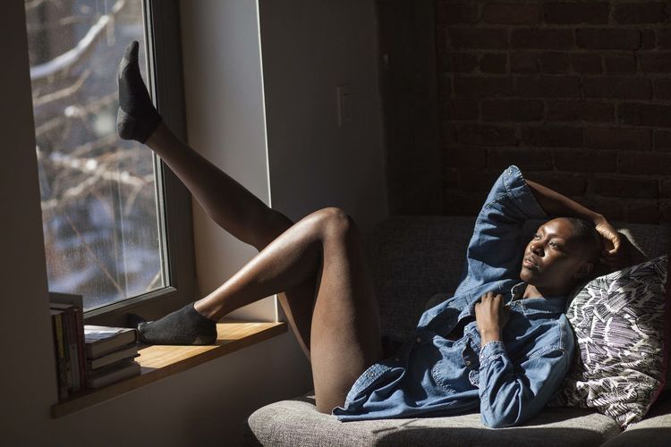 Woman looking out her window at home