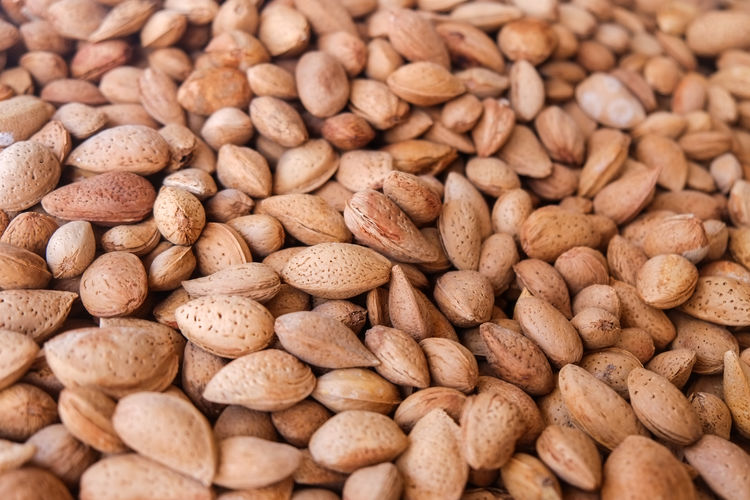 Heap whole organic almonds in shell sell in a nuts and dried fruits shop.