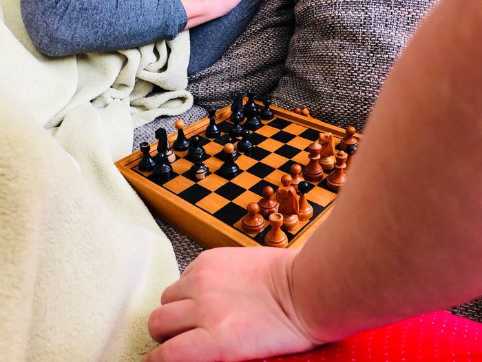 Cropped hands playing chess at home