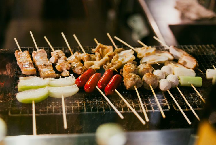 Close-up of yakitori skewers being grilled over charcoal