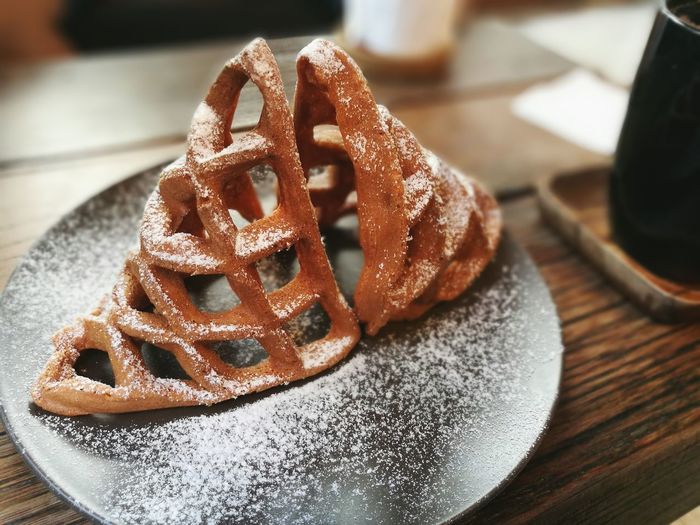 Close-up of waffle with powdered sugar on table
